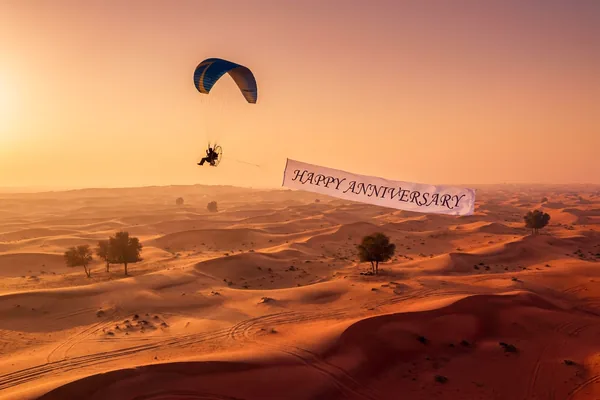 Paramotor circling the balloon with a celebration banner